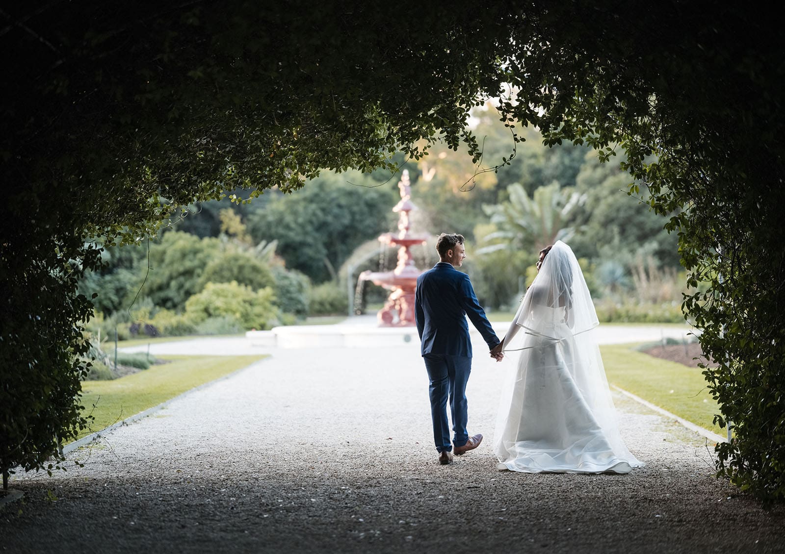 our lady of the rosary church wedding - lorraine & wayne 185 Bride and groom walking towards fountain