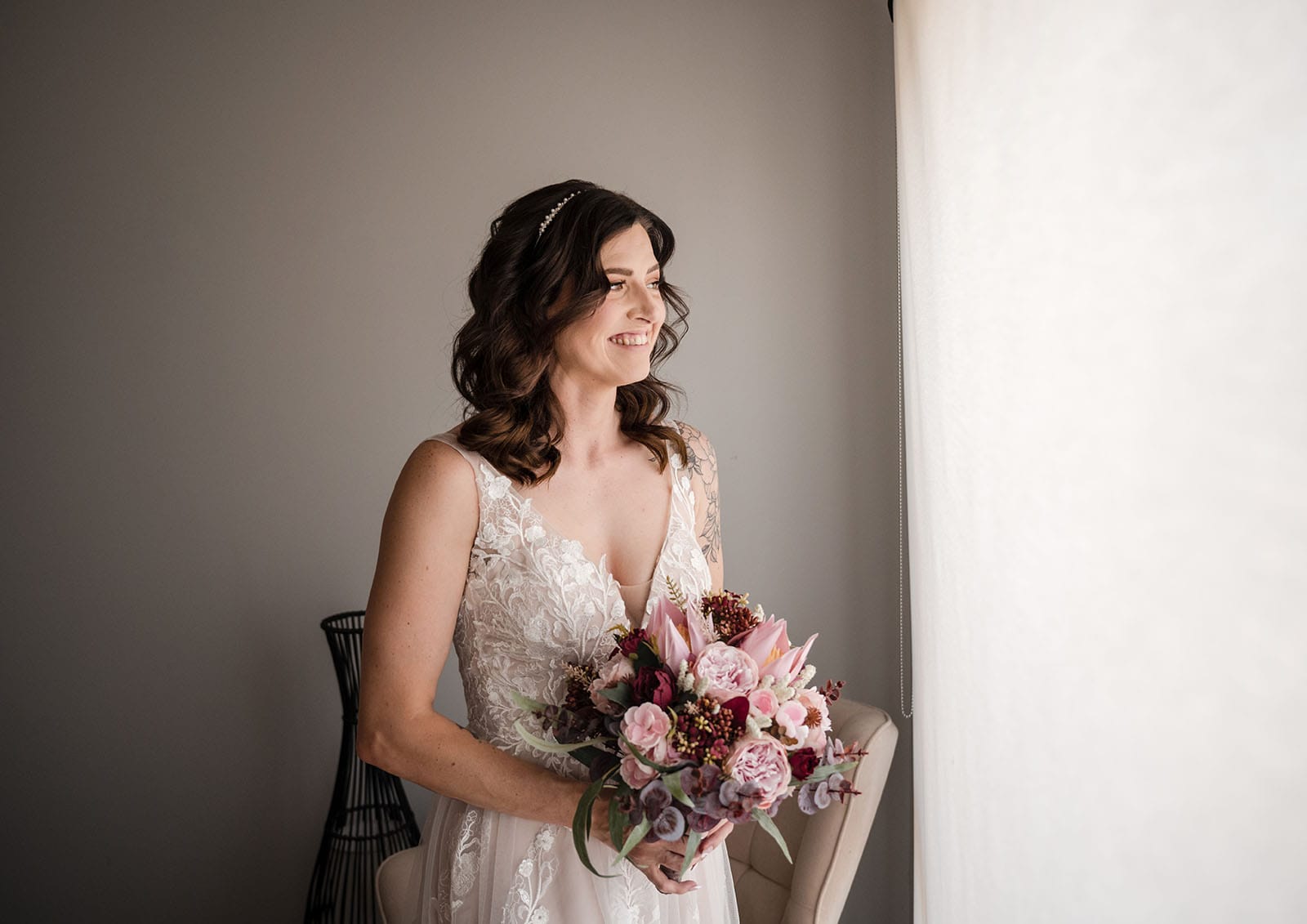 sneakys wedding - ash & michael 68 Bride holding flowers looking out window