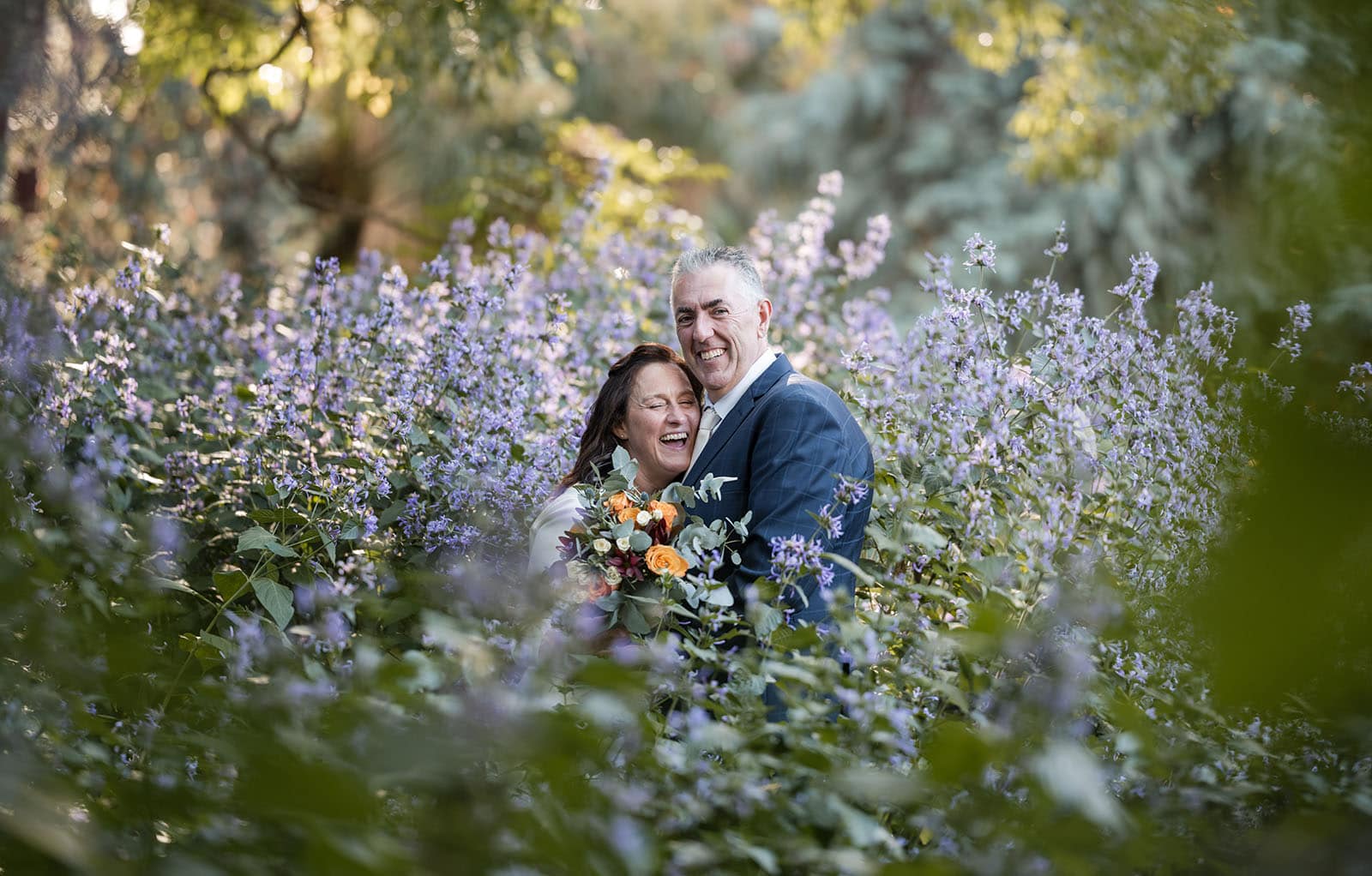 northern palm garden wedding - nicole & daryl 129 bride laughing in amongst purple flowers