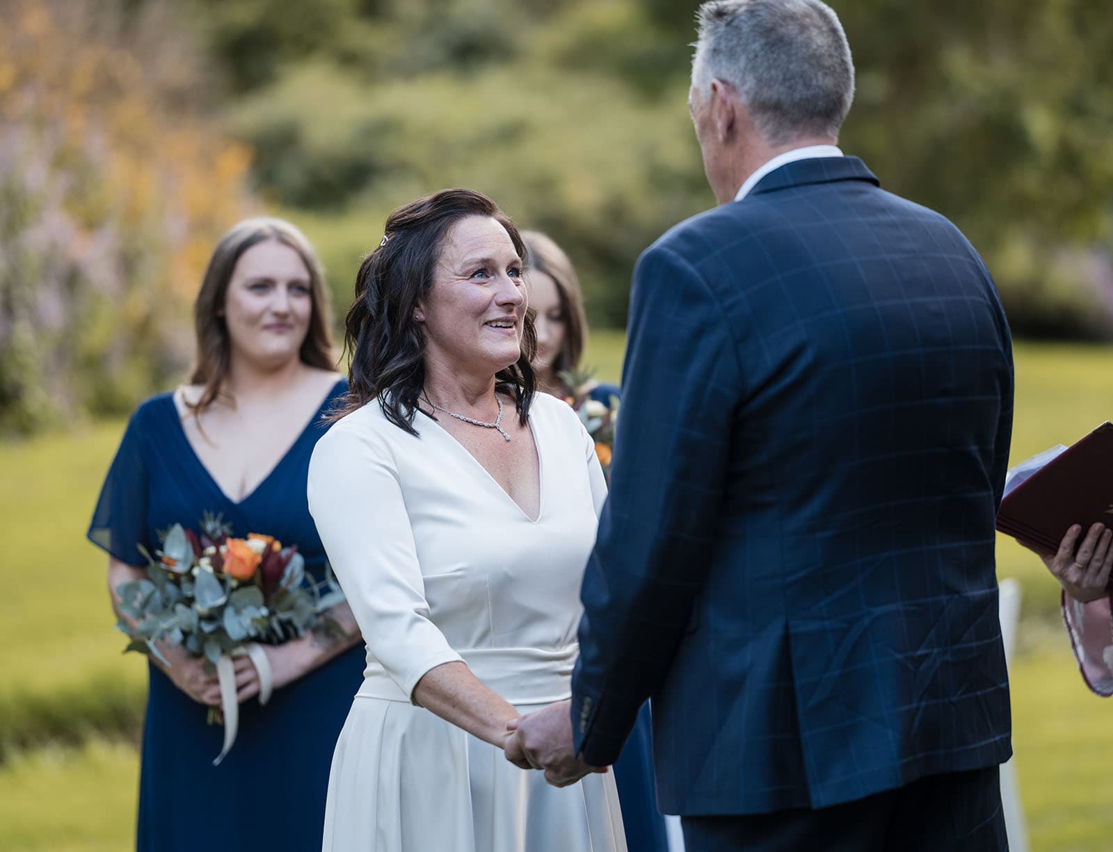 northern palm garden wedding - nicole & daryl 115 Bride smiling at her groom at ceremony
