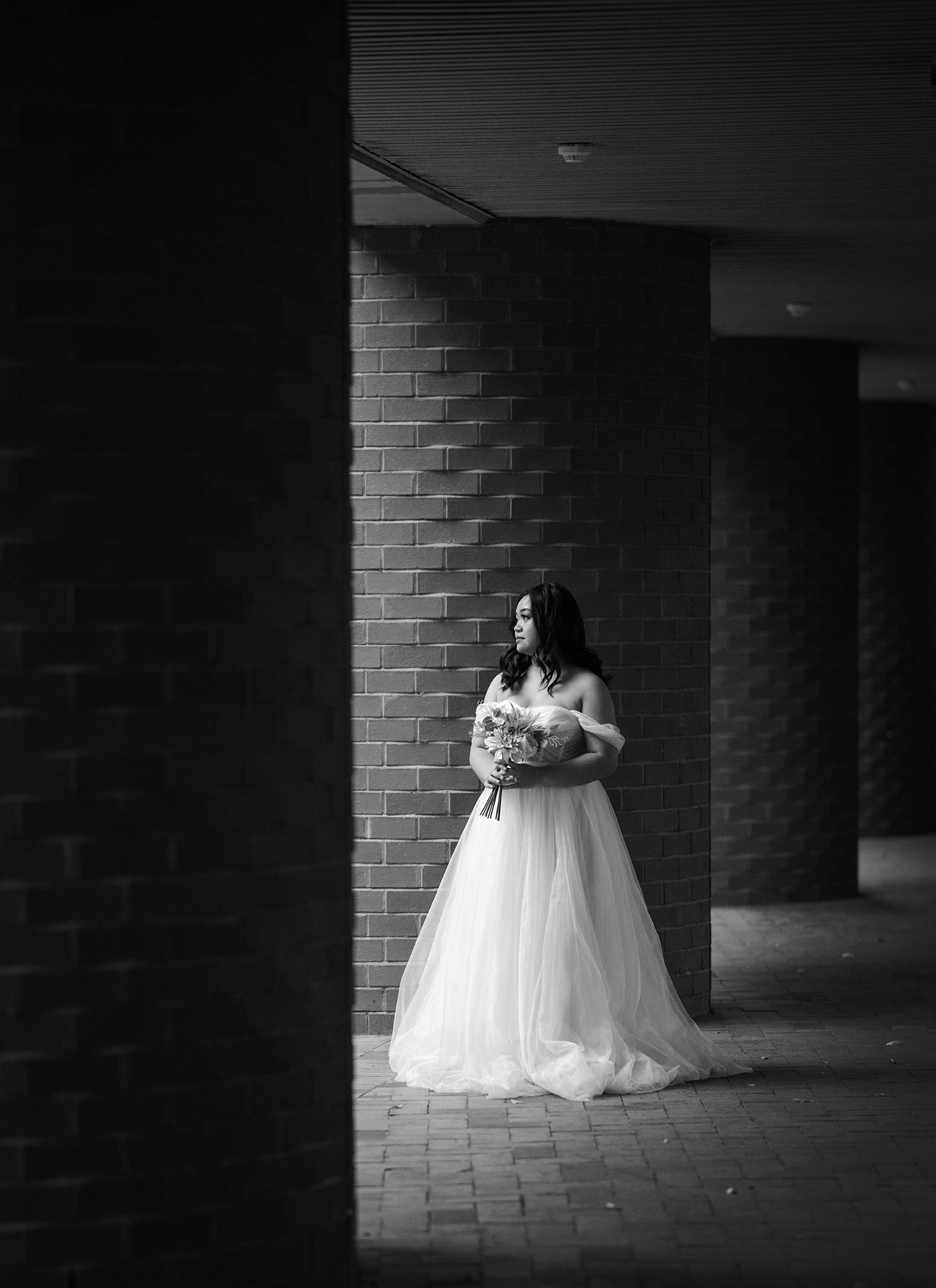 chesser st registration office wedding - khate & angelo 89 Bride standing alone in brick hallway