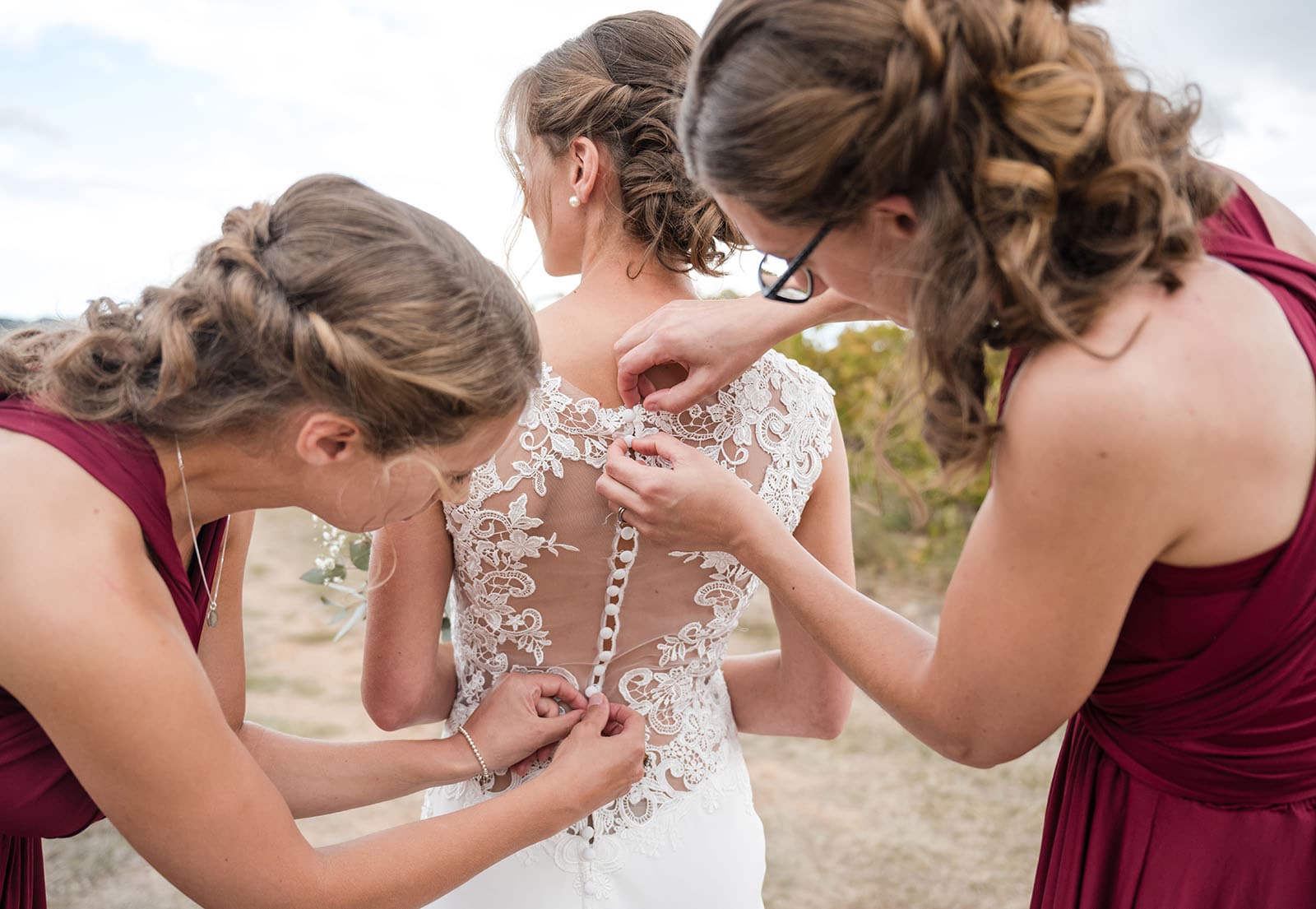 vine shed wedding - kat & katie 209 bridesmaids helping with gown buttons