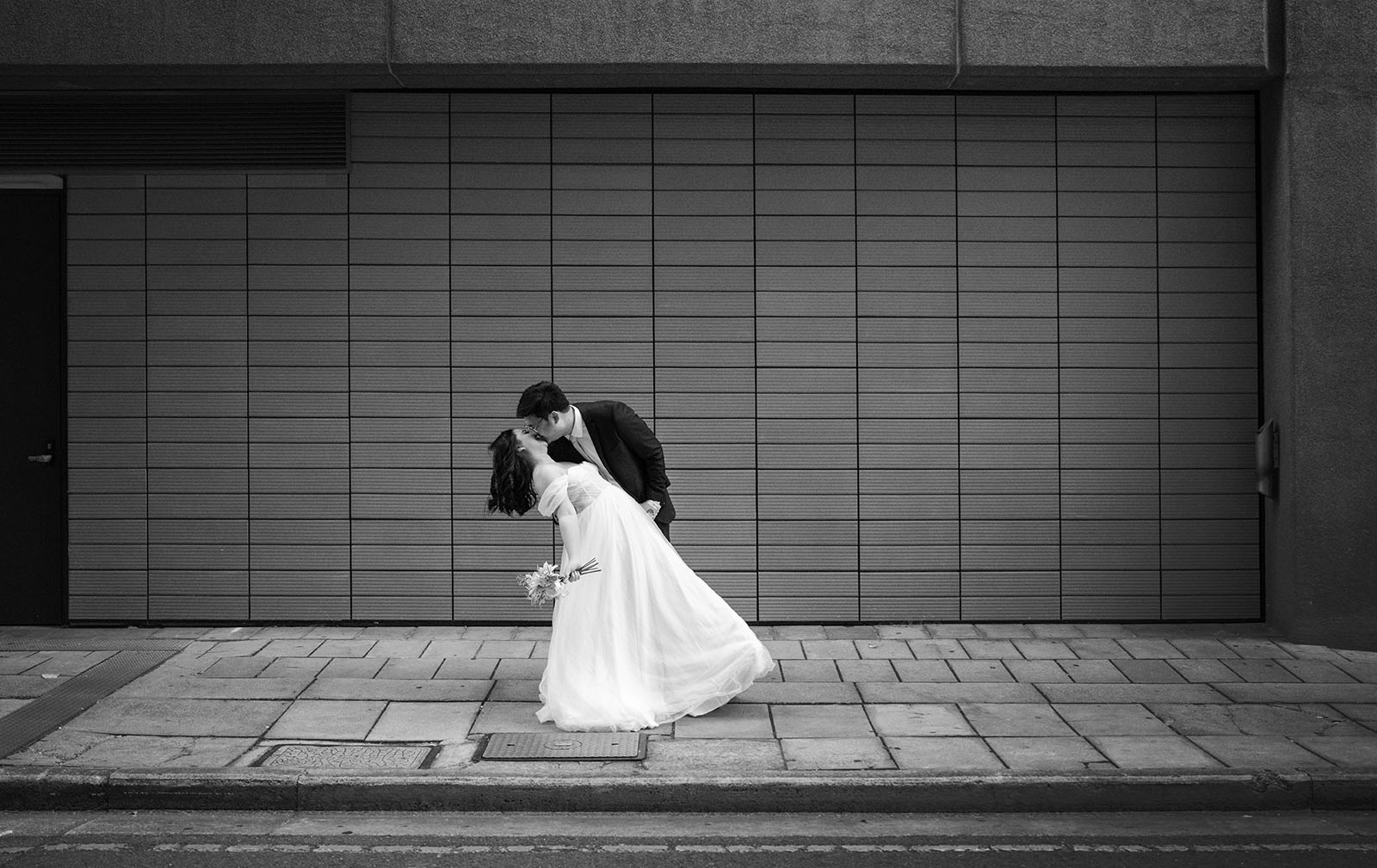 chesser st registration office wedding - khate & angelo 76 Groom kissing bride in front of wall