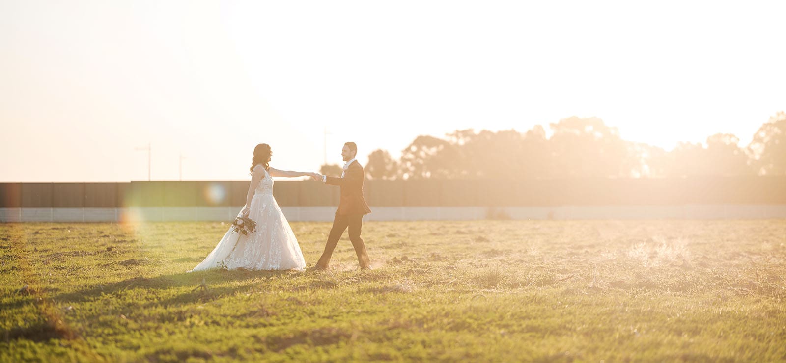 sneakys wedding - ash & michael 99 Groom leading bride across grass