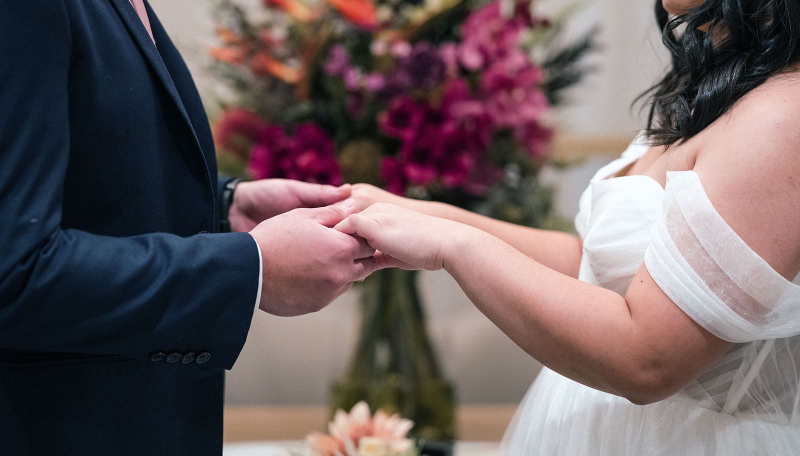 chesser st registration office wedding - khate & angelo 67 Holding hands in front of flowers