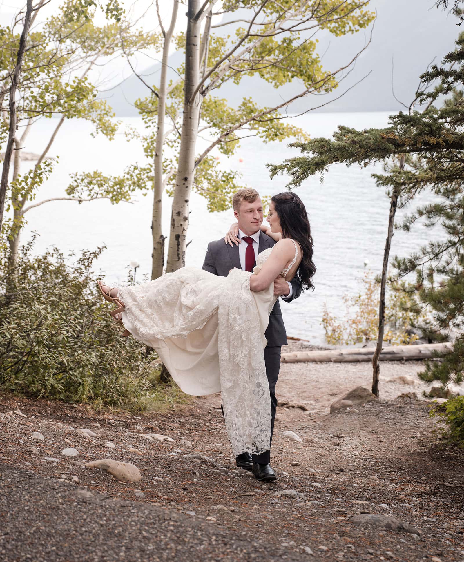 canada's lake louise wedding photoshoot - melodie & brandon 12 Lifting her up the banks of Lake Minnewanka