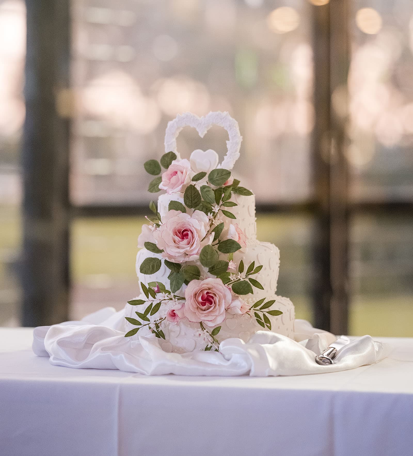 our lady of the rosary church wedding - lorraine & wayne 192 Two tier wedding cake with pink flower decorations