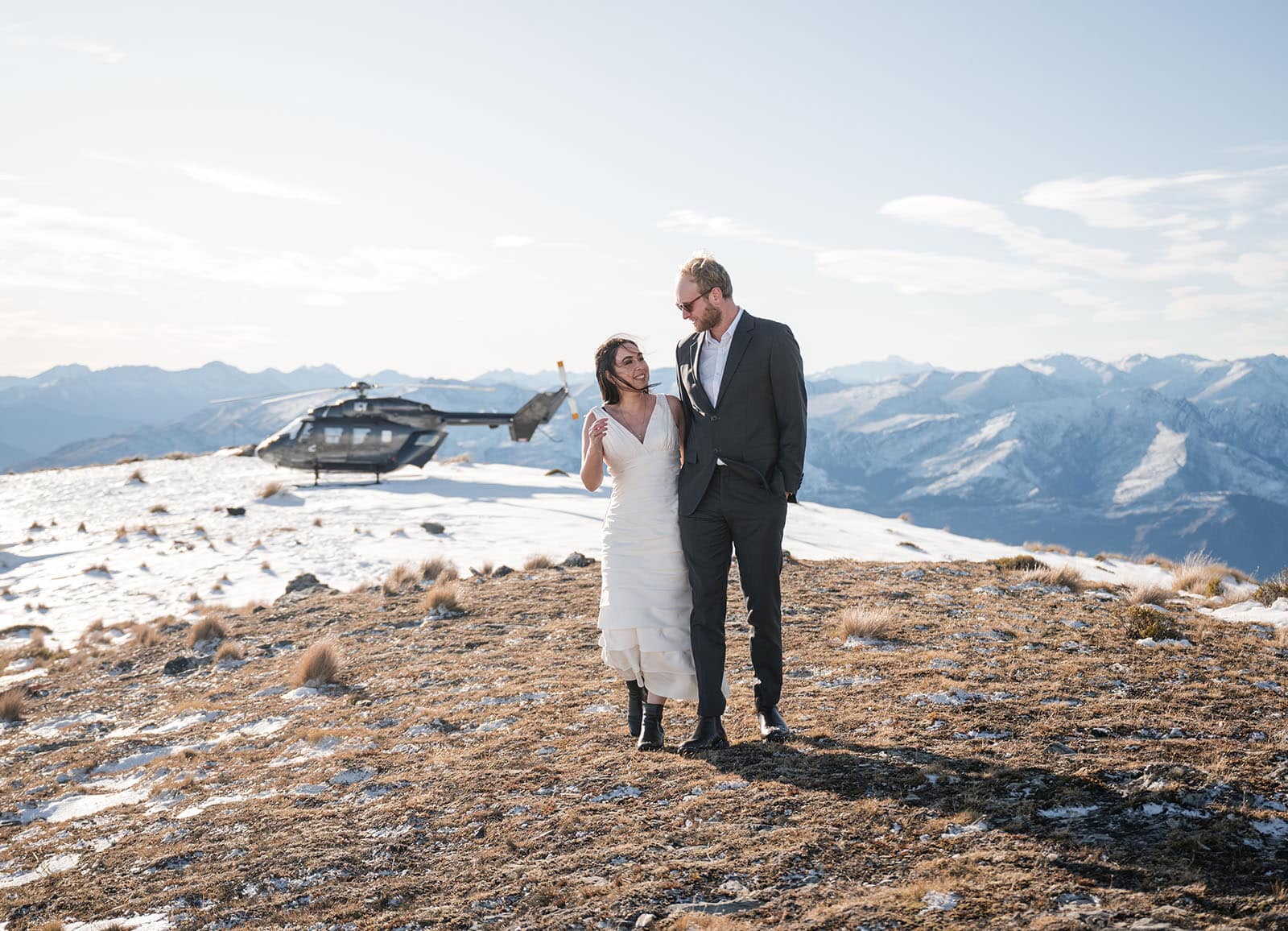 incredible queenstown wedding photoshoot - wendy & frank 32 Bridal couple walking away from Helicopter