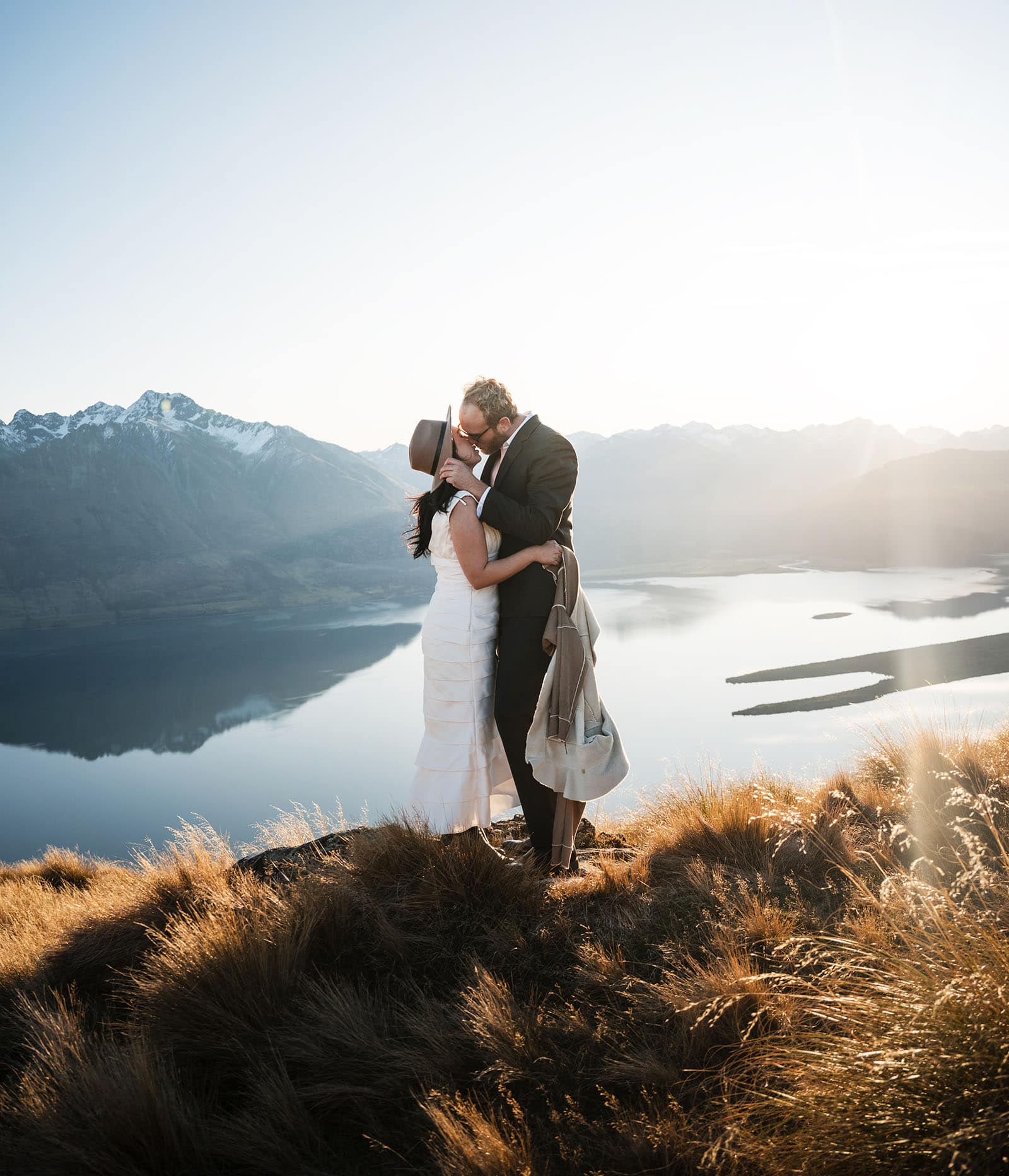 incredible queenstown wedding photoshoot - wendy & frank 50 Bride and groom kiss on mountain top