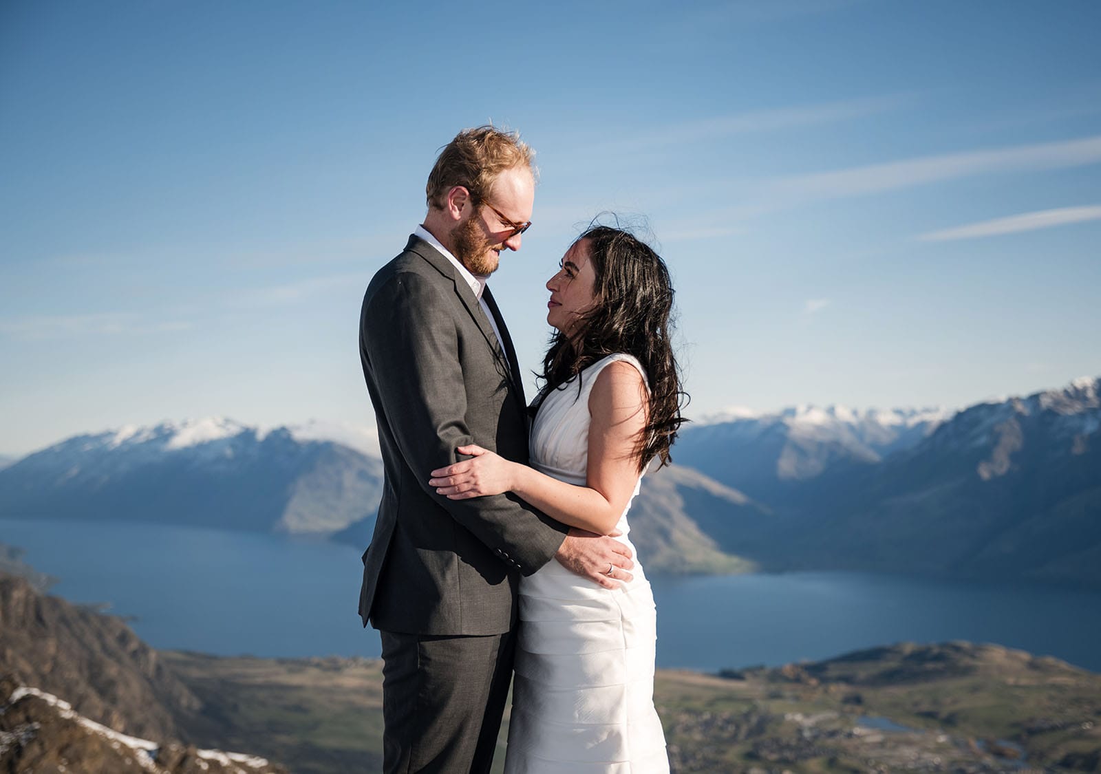 incredible queenstown wedding photoshoot - wendy & frank 34 Bride and groom looking at one another in front of lake view