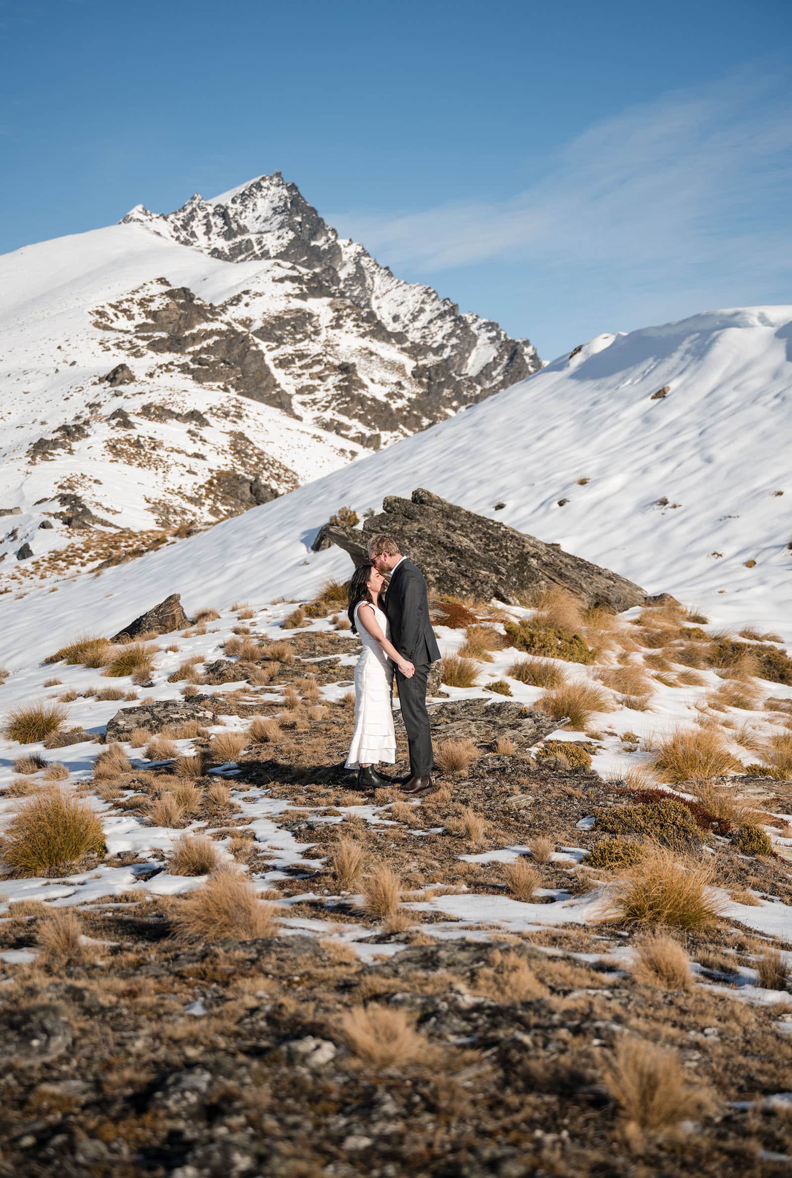 incredible queenstown wedding photoshoot - wendy & frank 28 Bride and groom under shadow of mountain