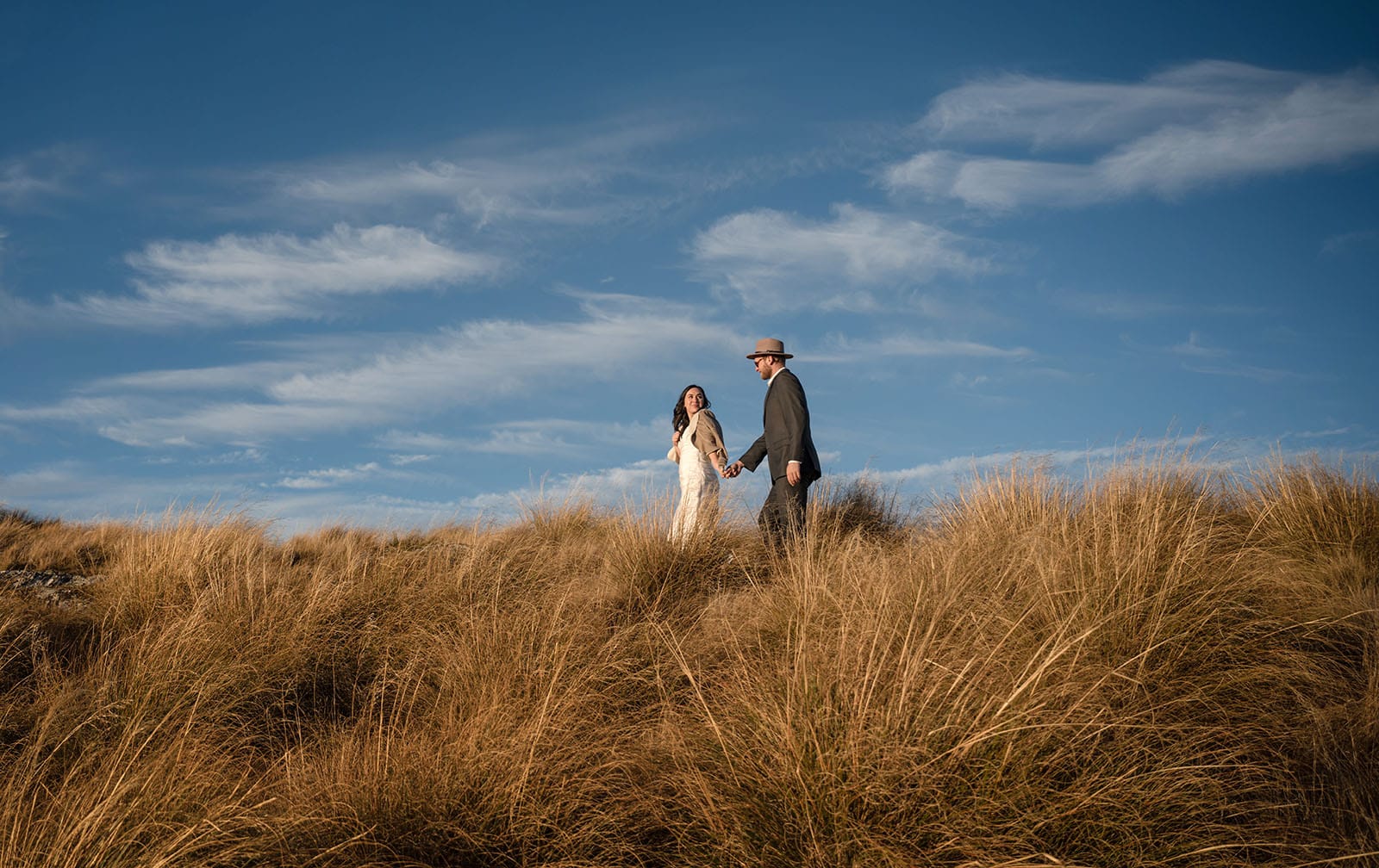incredible queenstown wedding photoshoot - wendy & frank 48 bride leading groom under blue sky