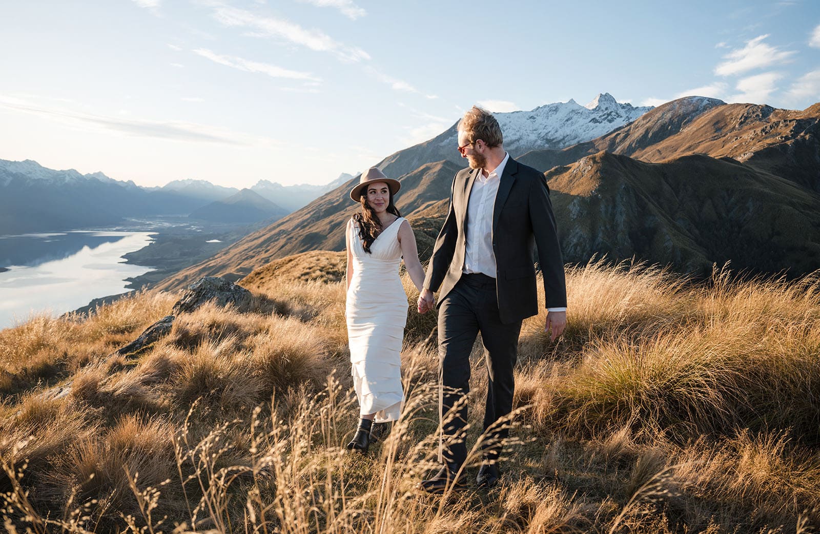 incredible queenstown wedding photoshoot - wendy & frank 53 Groom leading bride back to helicopter