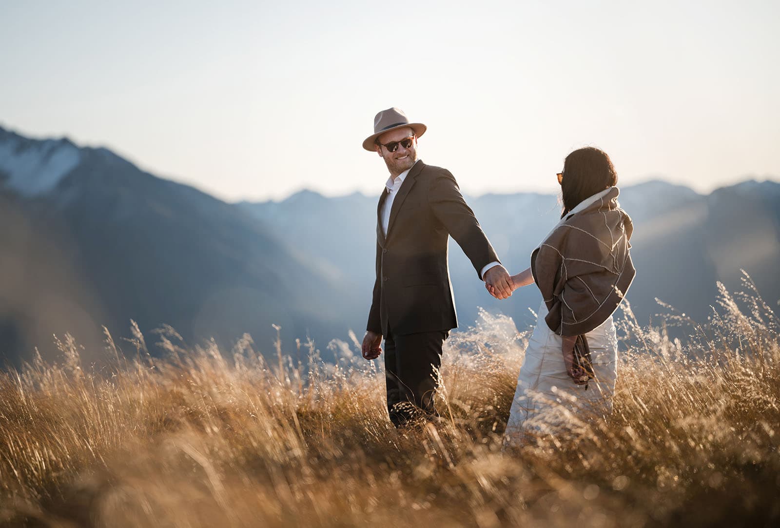 incredible queenstown wedding photoshoot - wendy & frank 58 Groom leading bride through long grass