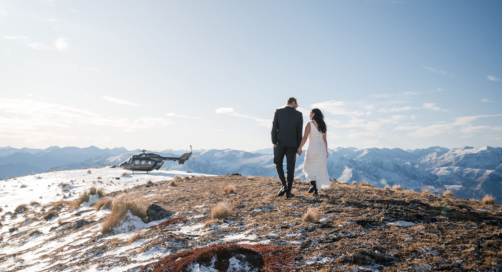 incredible queenstown wedding photoshoot - wendy & frank 38 Walking to the helicopter on the mountain peak