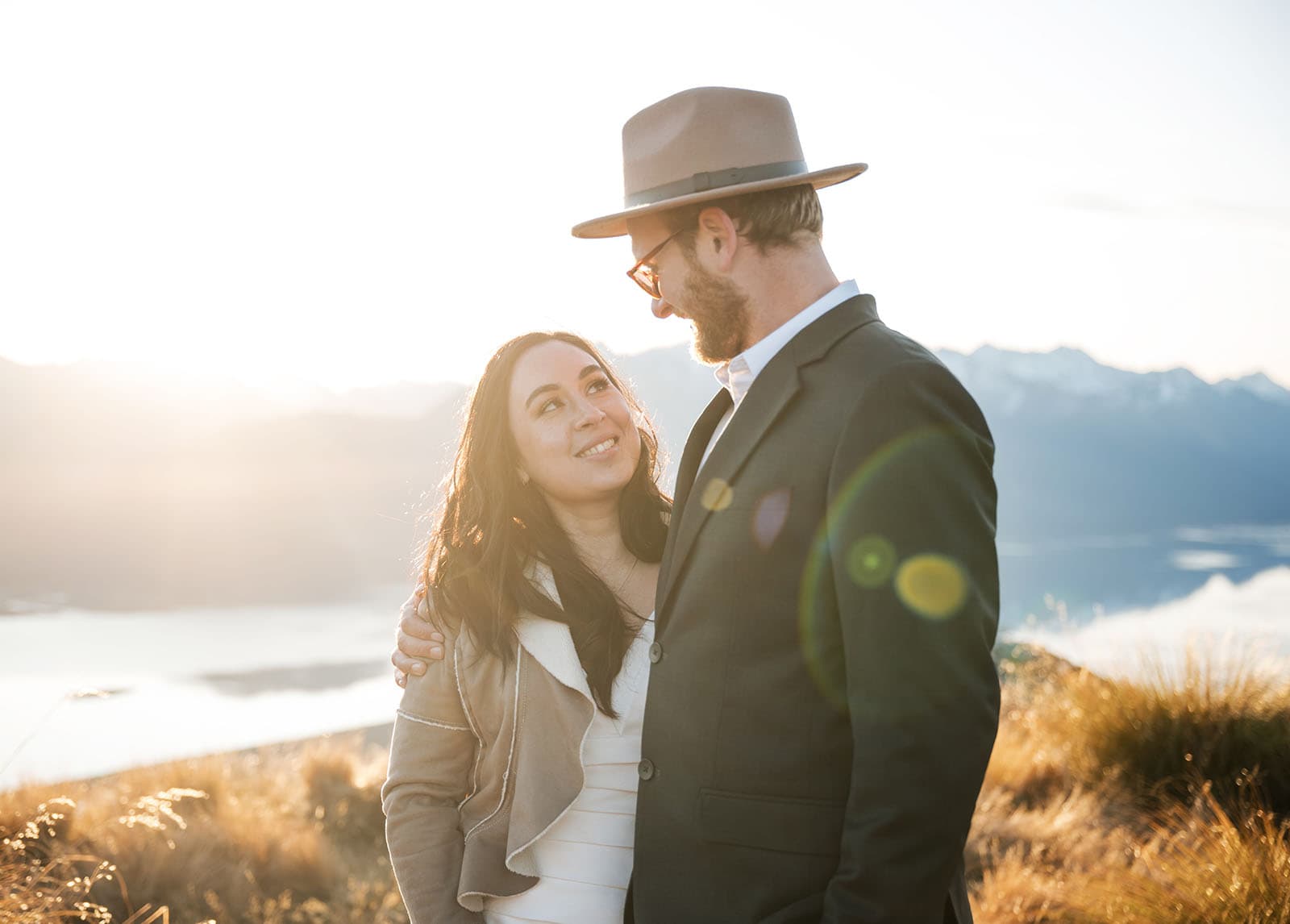 incredible queenstown wedding photoshoot - wendy & frank 56 Lens flare beaming between bridal couple