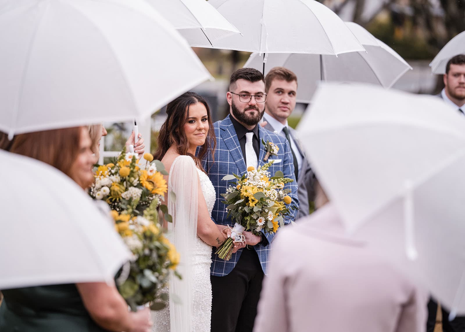 the house on haines wedding - emily & andrew 207 bride and groom peeking through umbrellas during ceremony
