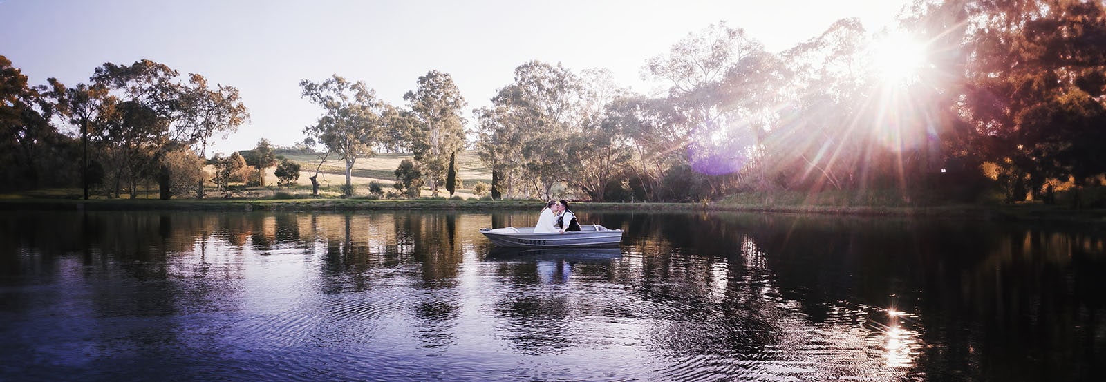 tiny house on the prairie wedding - kat & stacey 107 Bridal couple in boat under sun