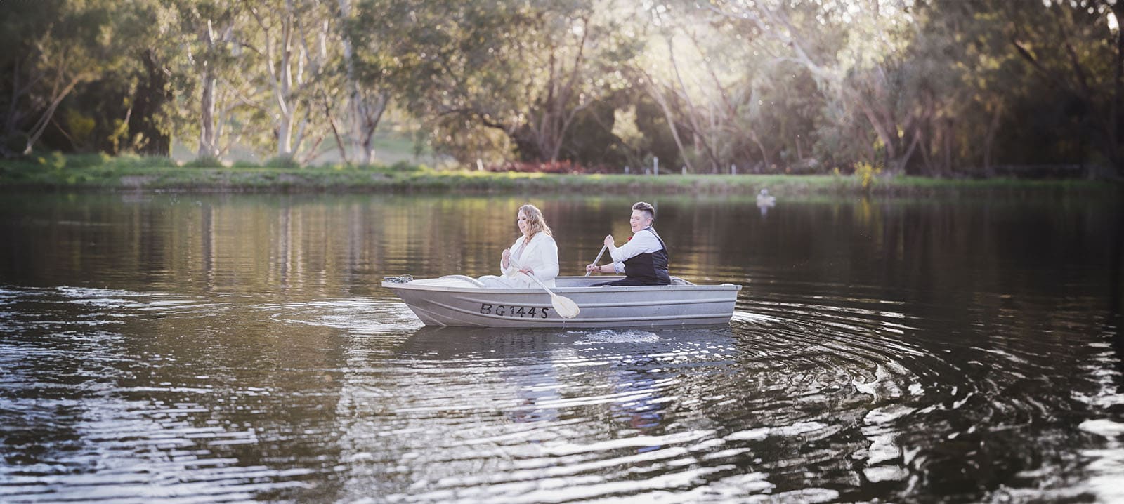 tiny house on the prairie wedding - kat & stacey 104 Bridal couple rowing in boat
