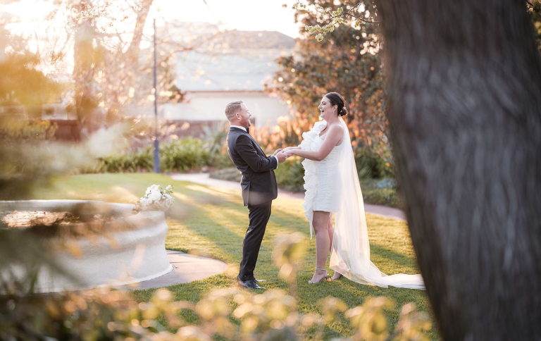 Bride and groom playing in garden