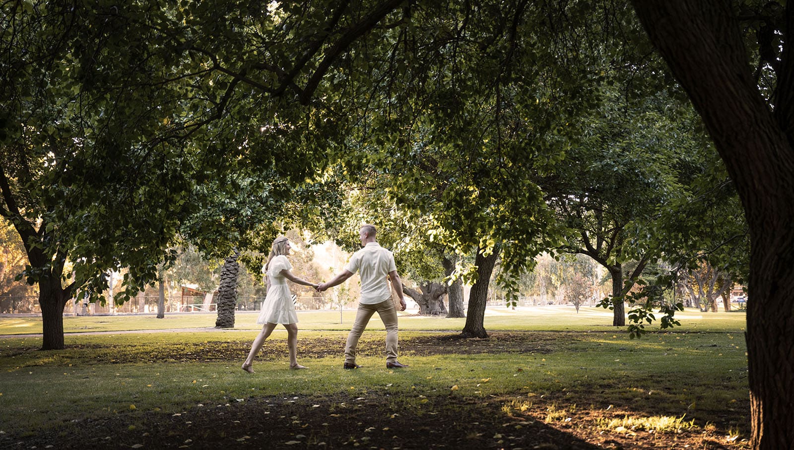 adelaide parklands engagement shoot - stacey & jacob 197 Couple walking under tree foliage
