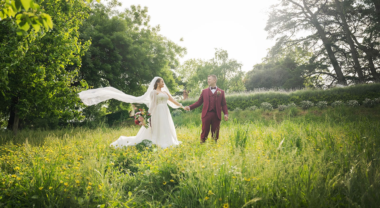 templewood house wedding - michelle & andrew 30 Groom leading bride through long grass