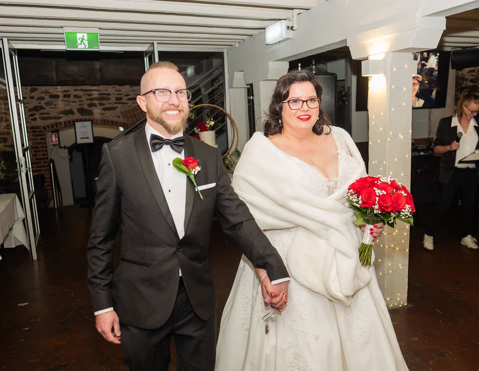 botanic gardens palm house wedding - kelly & david 126 Kelly and David enter their wedding reception holding hands, with Kelly carrying a bouquet of red roses.