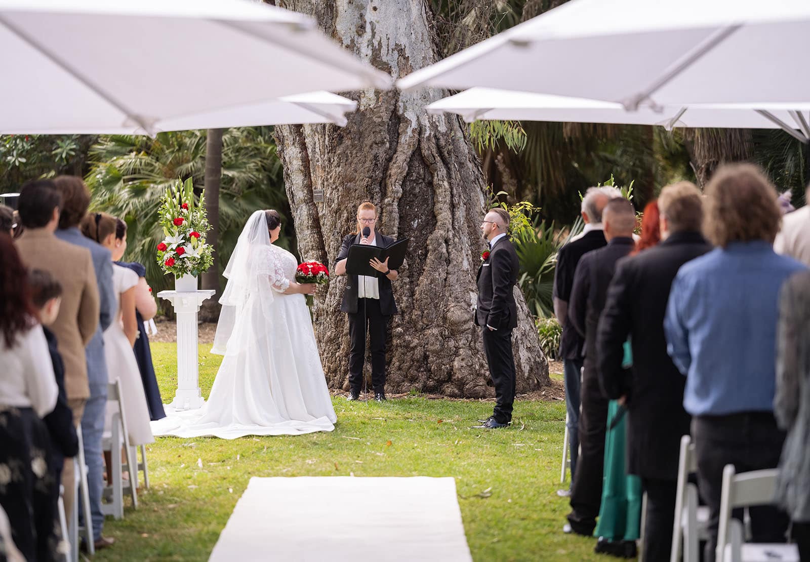 botanic gardens palm house wedding - kelly & david 95 Bride and groom standing with their celebrant beneath a large gum tree during a wedding ceremony in Adelaide Botanic Gardens