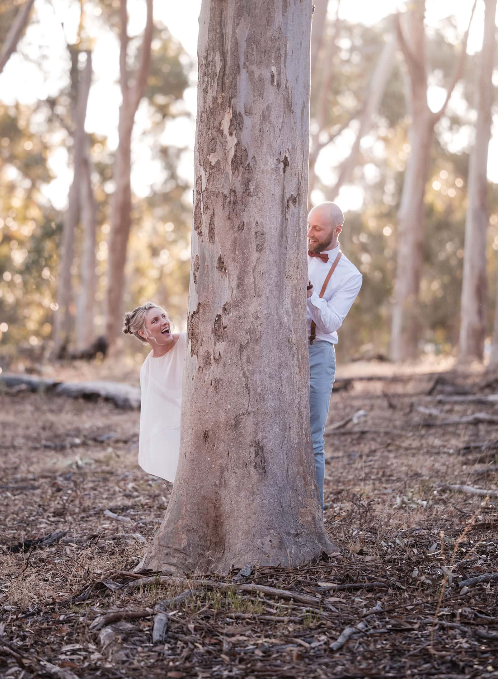 belair national park engagement shoot - lindsey & jaden 16 Couple playing hide and seek around tree outdoors