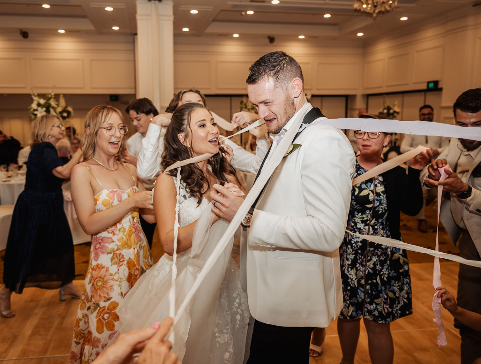 glenelg's partridge house wedding - bec & matt 88 joyful wedding reception with couple playing ribbon game