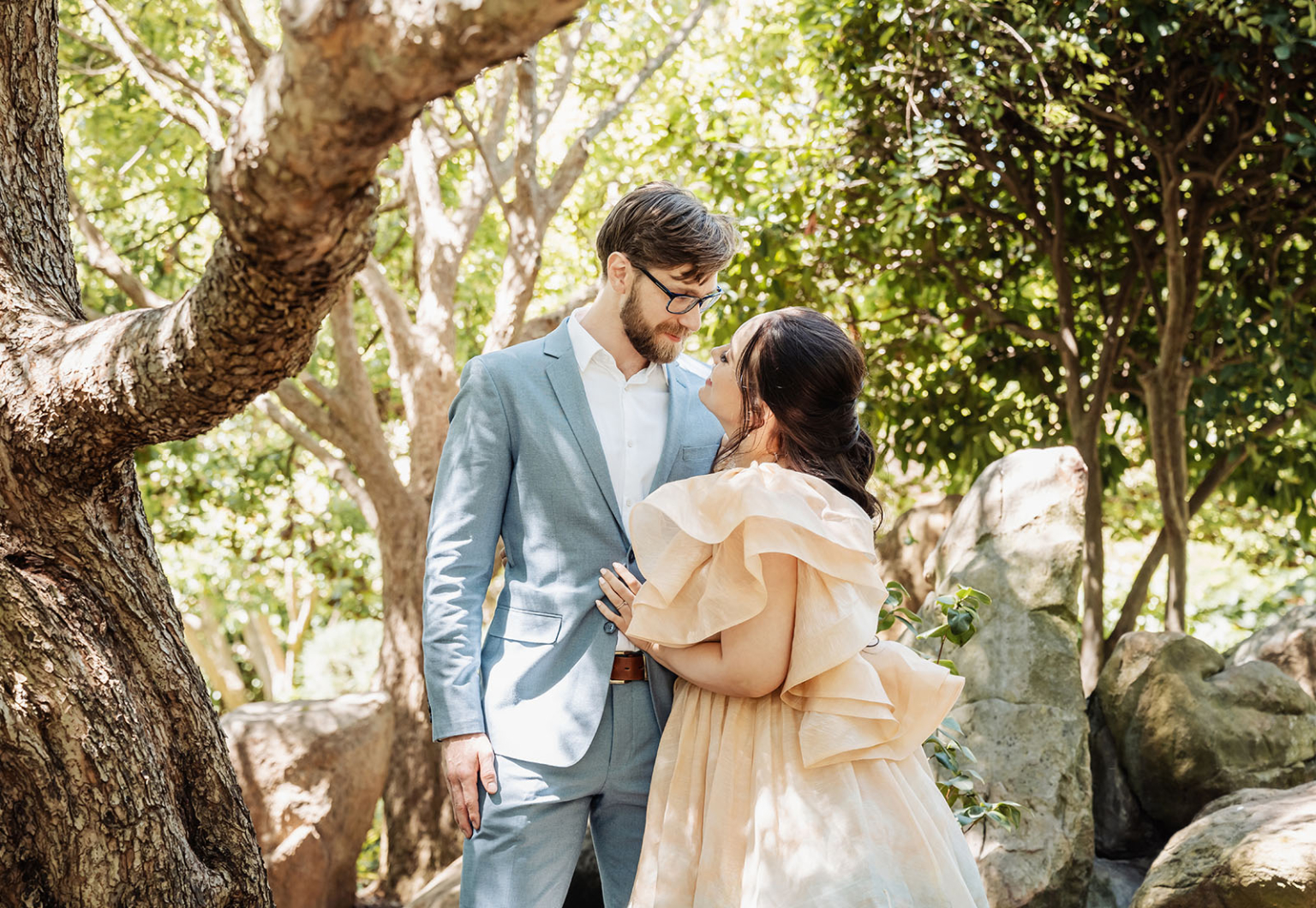 adelaide marriage registration office wedding - claudia & chevy 97 Engaged couple hugging in sunlit woods.