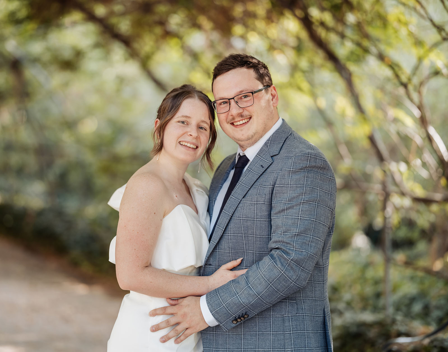 chesser street office wedding - rachele & jacob 2 Joyful couple embracing in formal attire amidst a serene natural setting.