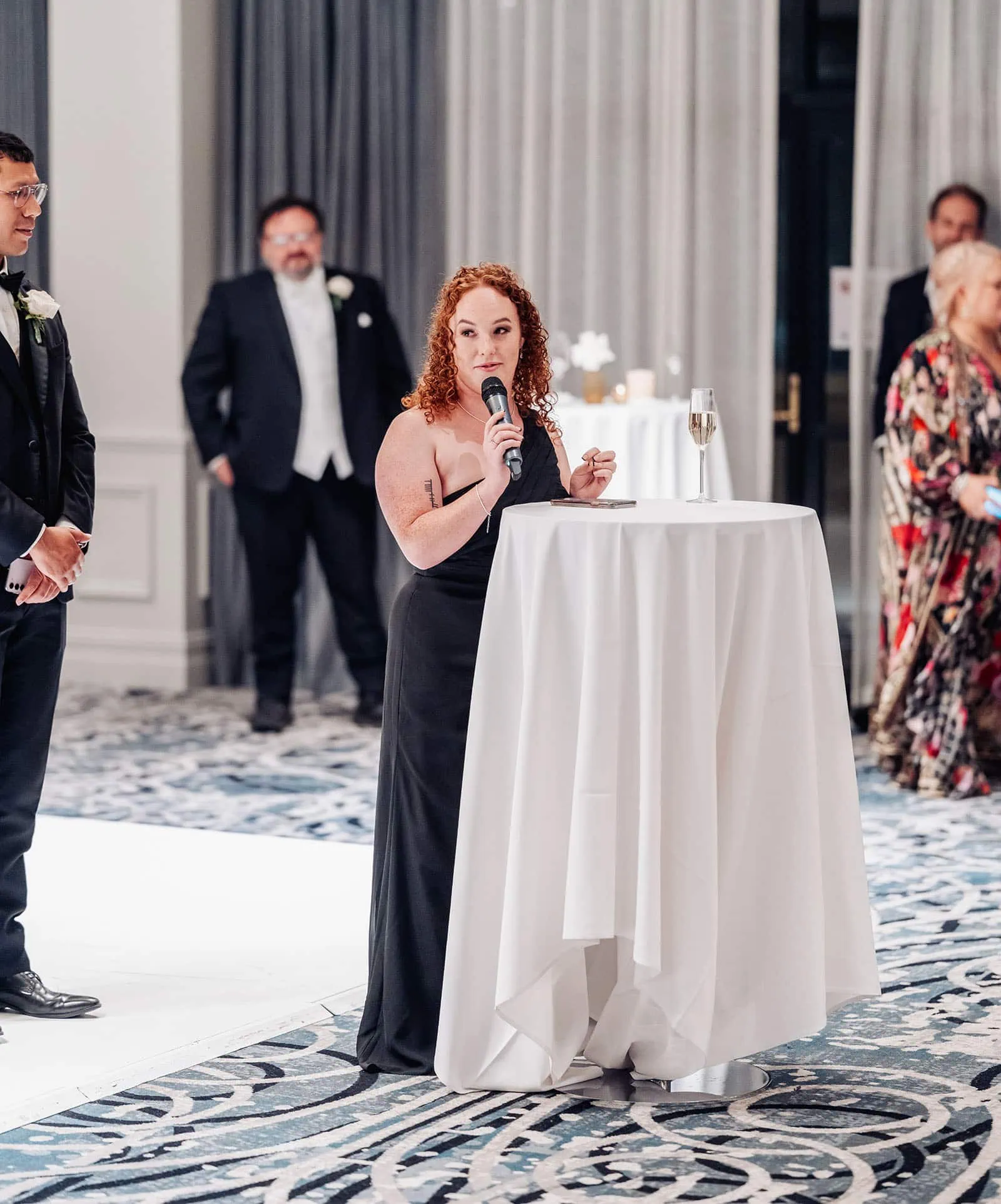 botanic gardens, araucaria avenue wedding - jade & hazim 71 Elegant woman delivering heartfelt speech at formal event in black gown.