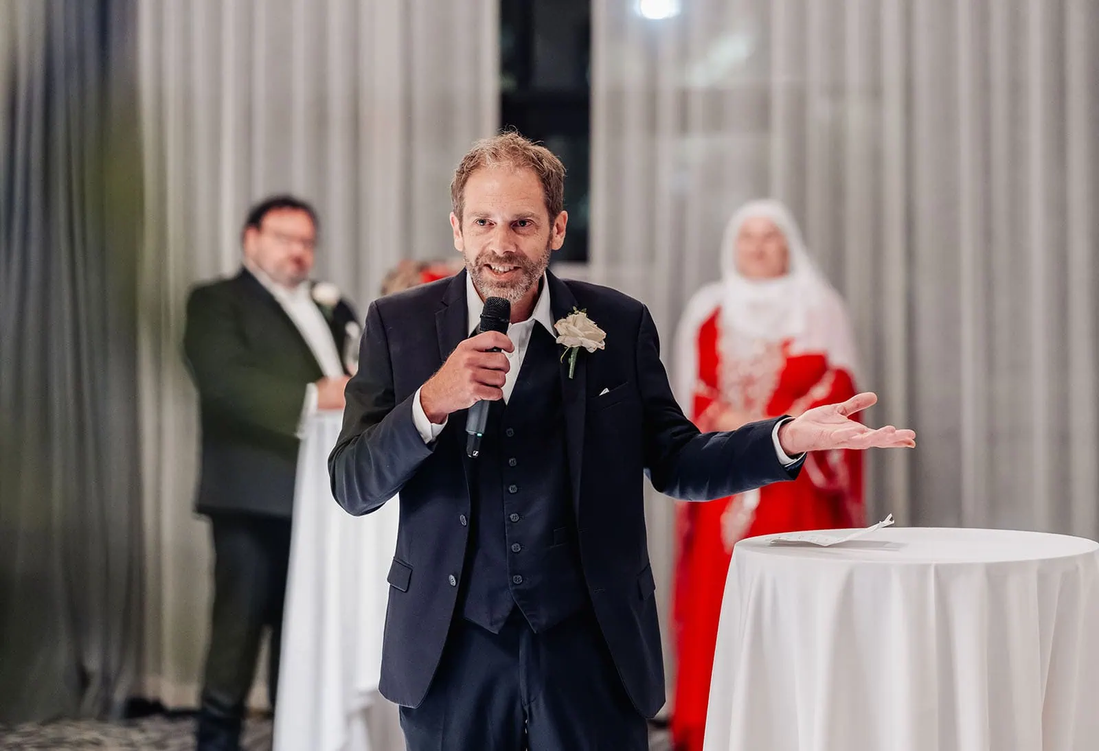 botanic gardens, araucaria avenue wedding - jade & hazim 69 Man in suit delivering speech at wedding reception with microphone.