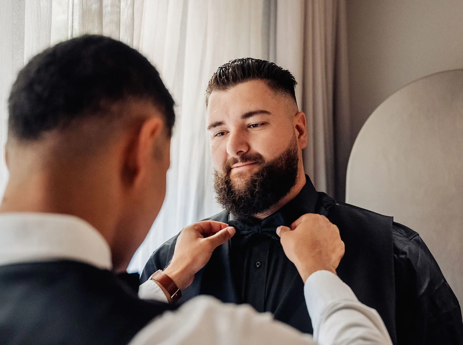 botanic gardens, araucaria avenue wedding - jade & hazim 5 Stylish man in formal attire getting his bow tie adjusted before a special event.
