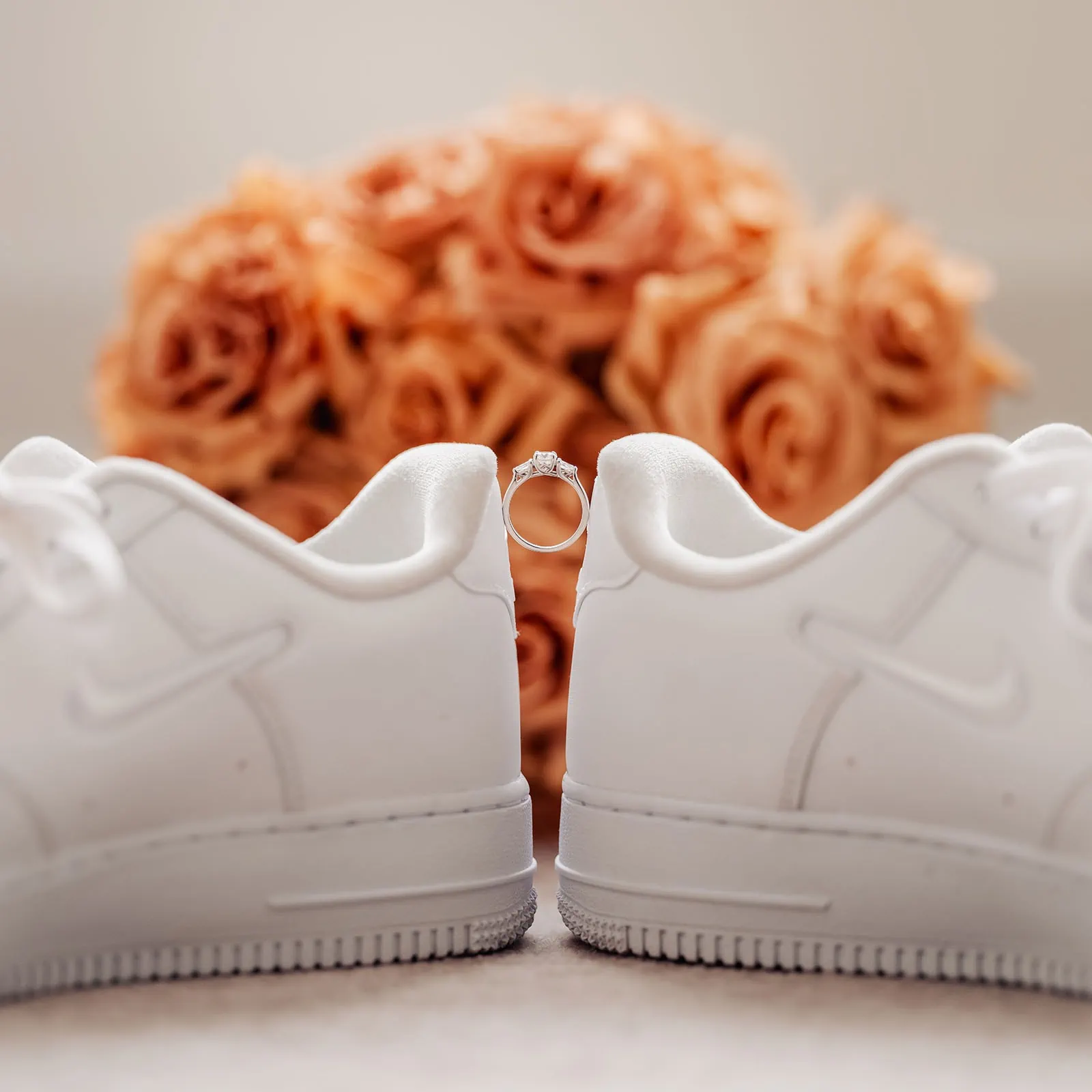 botanic gardens, araucaria avenue wedding - jade & hazim 14 White sneakers, diamond engagement ring, and peach roses symbolizing modern wedding concept.