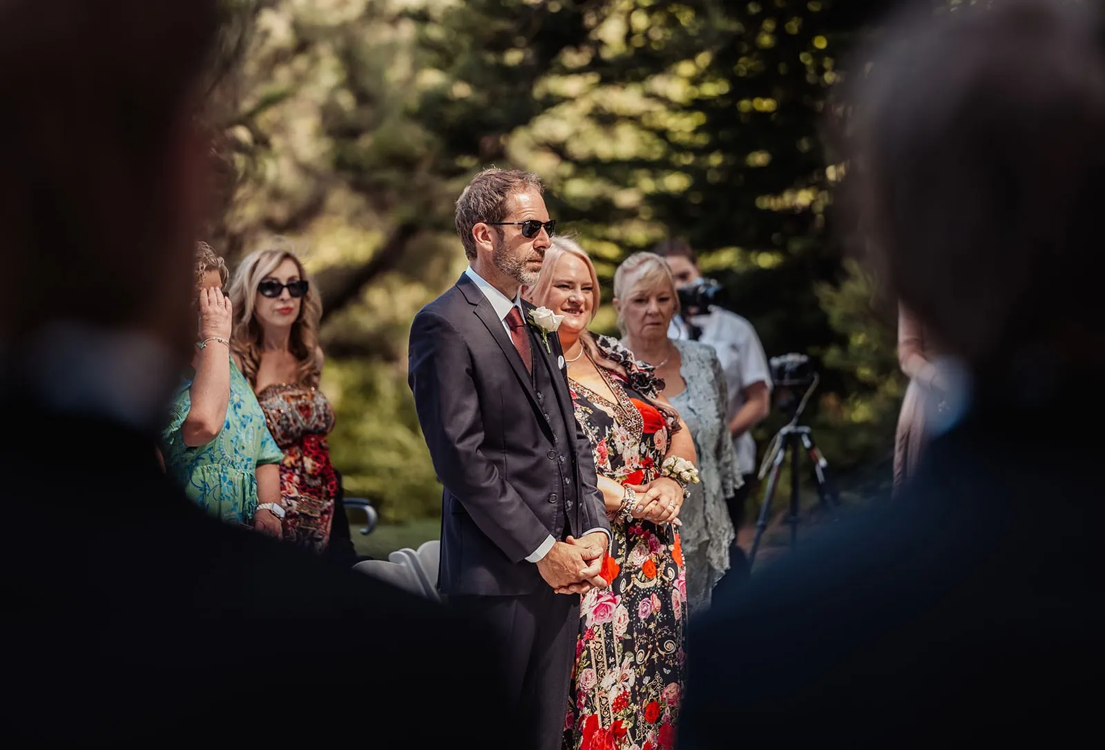 botanic gardens, araucaria avenue wedding - jade & hazim 34 Couple holding hands at sunny outdoor wedding ceremony.