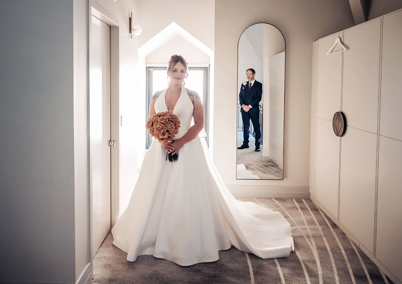 botanic gardens, araucaria avenue wedding - jade & hazim 24 Bride in white gown with grooms reflection in mirror in modern wedding setting.