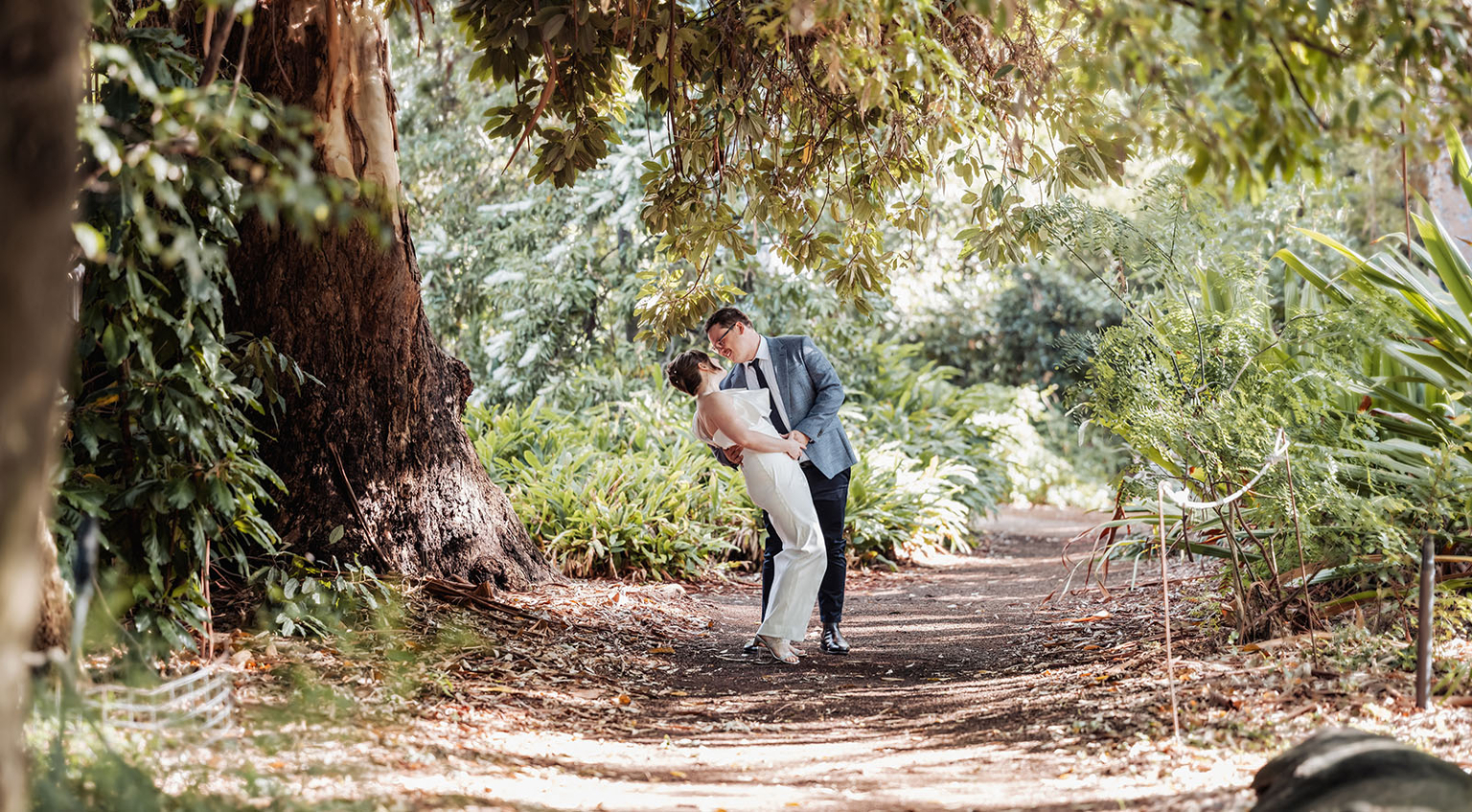 chesser street office wedding - rachele & jacob 1 Couple sharing a romantic moment in a lush, sunlit garden.