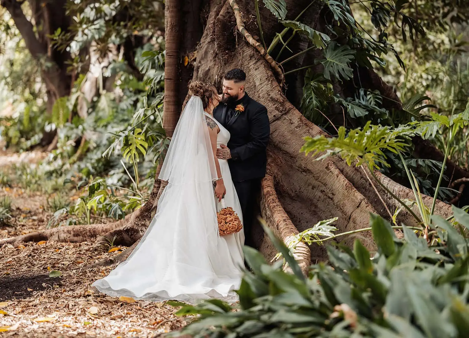 botanic gardens, araucaria avenue wedding - jade & hazim 52 Bride and groom sharing a moment in an autumnal forest setting on their wedding day.