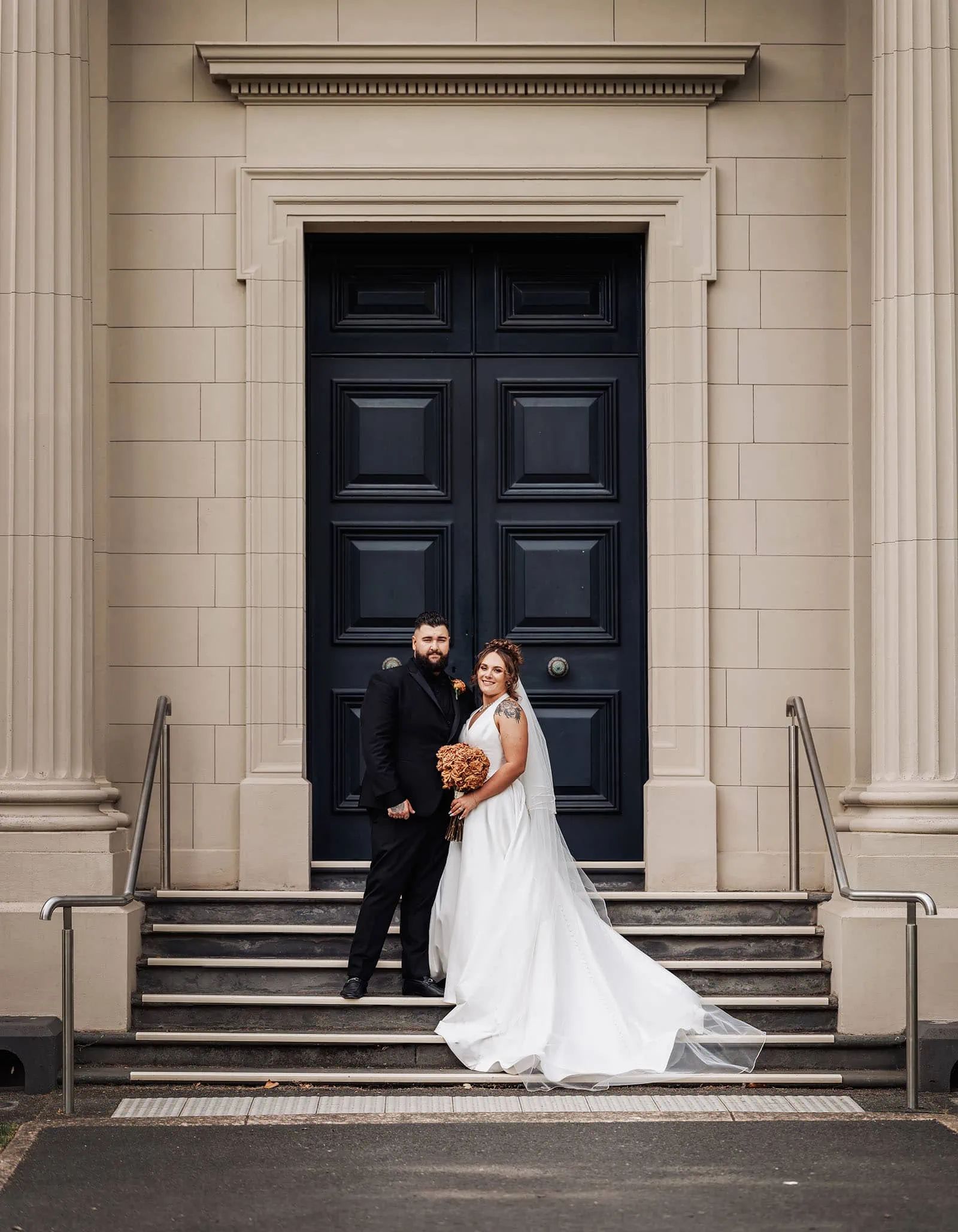 botanic gardens, araucaria avenue wedding - jade & hazim 59 Elegant bride and groom posing at grand entrance with blue door.