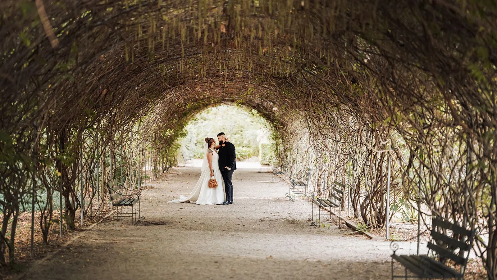 botanic gardens, araucaria avenue wedding - jade & hazim 60 Bride and groom sharing intimate moment in enchanting garden archway.