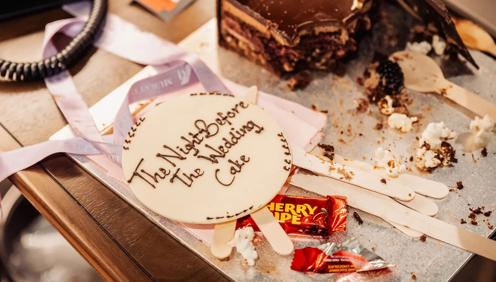 botanic gardens, araucaria avenue wedding - jade & hazim 6 Remnants of a pre-wedding celebration chocolate cake surrounded by popcorn and wrapped candies.