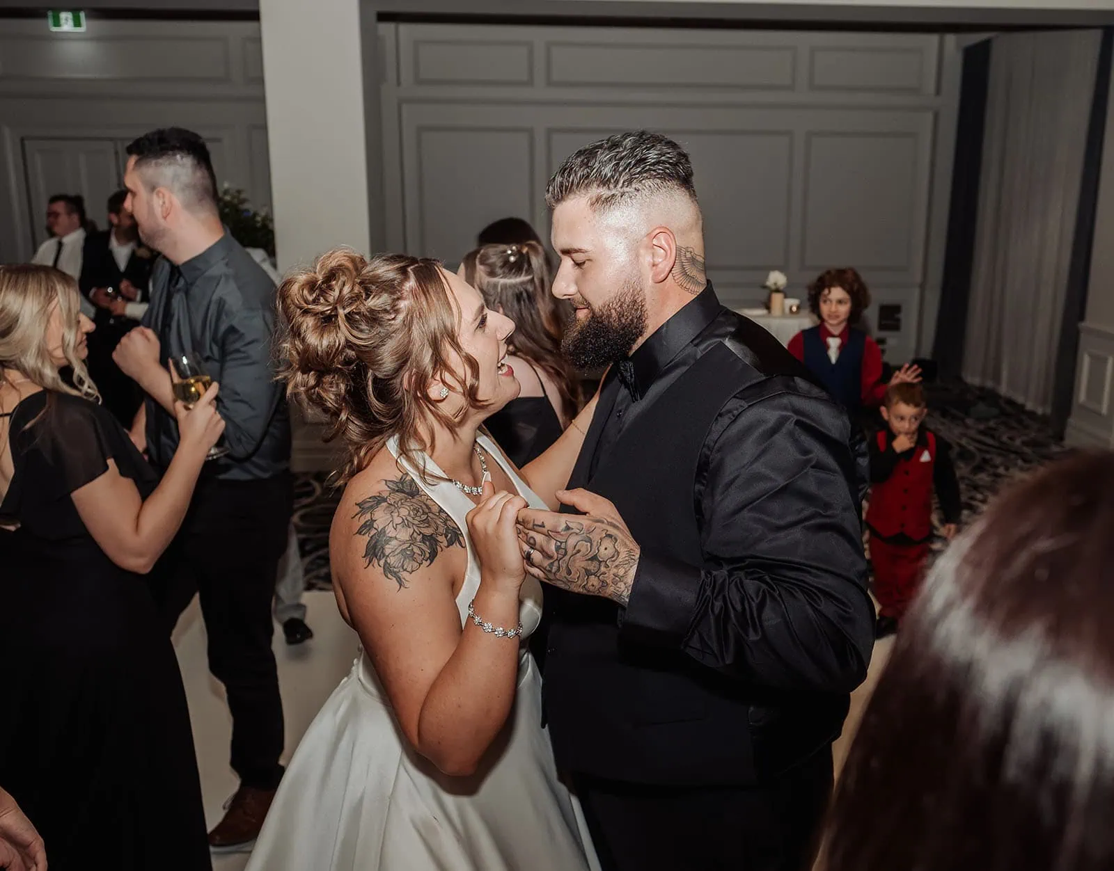 botanic gardens, araucaria avenue wedding - jade & hazim 73 Bride and groom with tattoos joyfully dancing at their modern wedding reception.