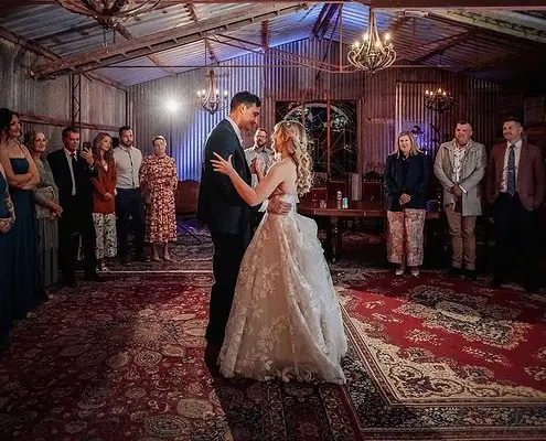 Aldinga Secret Garden wedding couple sharing their first dance in rustic barn setting.