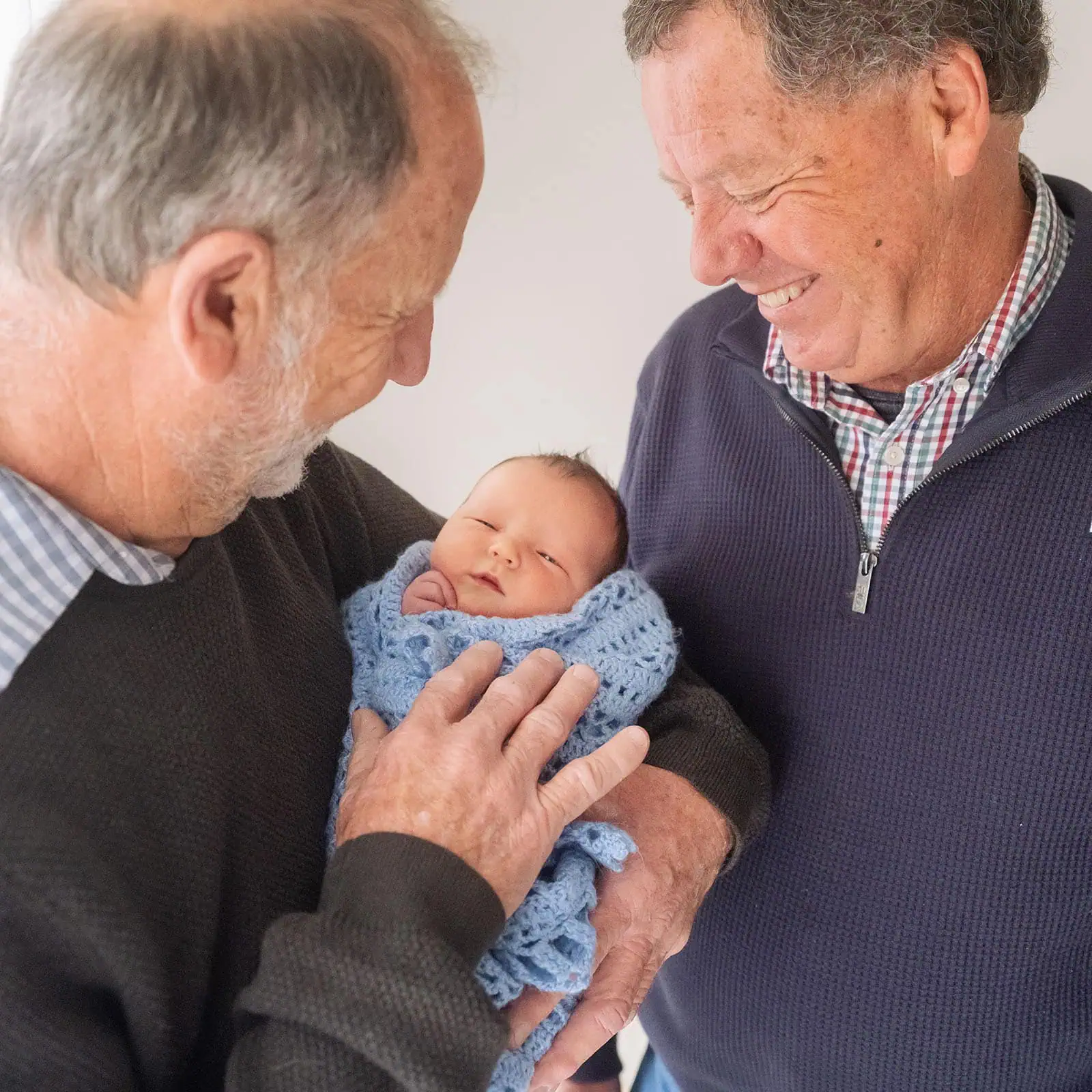 baby joshua's newborn photo shoot 44 Two grandfathers admiring newborn baby.