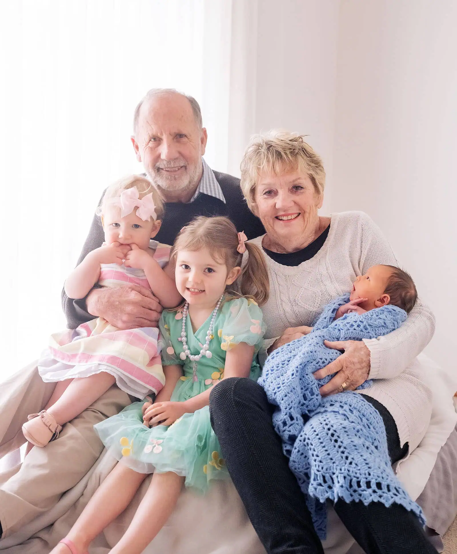 baby joshua's newborn photo shoot 42 Three generations: Grandparents with three young grandchildren in a cozy, light-filled home.
