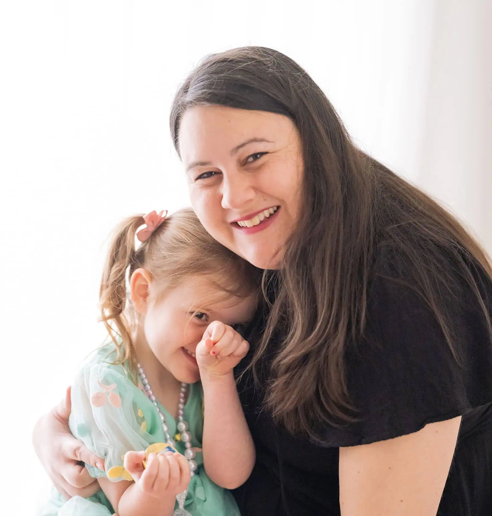 baby joshua's newborn photo shoot 45 Mother and daughter sharing a joyful hug and smile.
