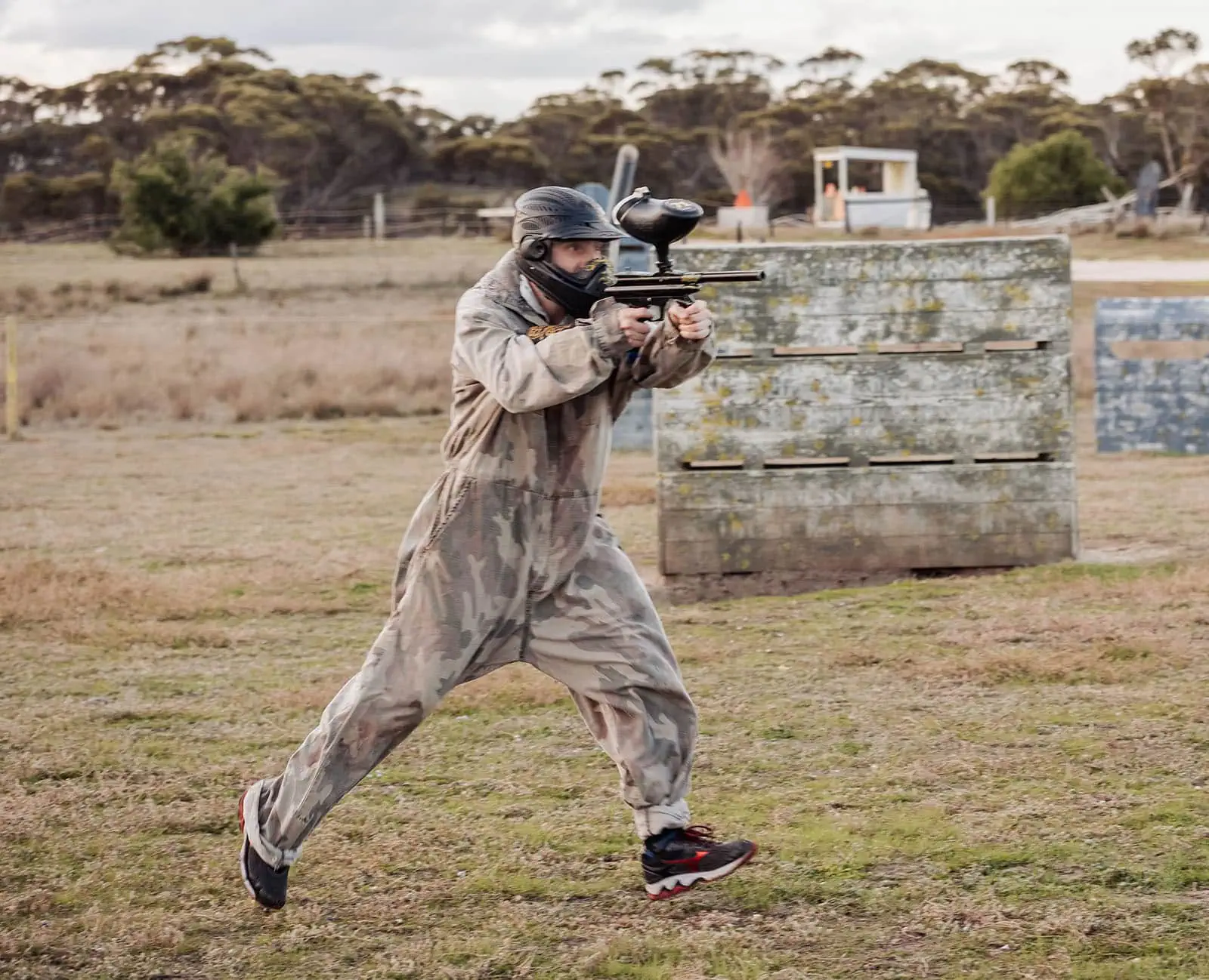 monarto delta force bucks vs hens paintball party 36 Paintball player in camouflage running with gun in an outdoor field.