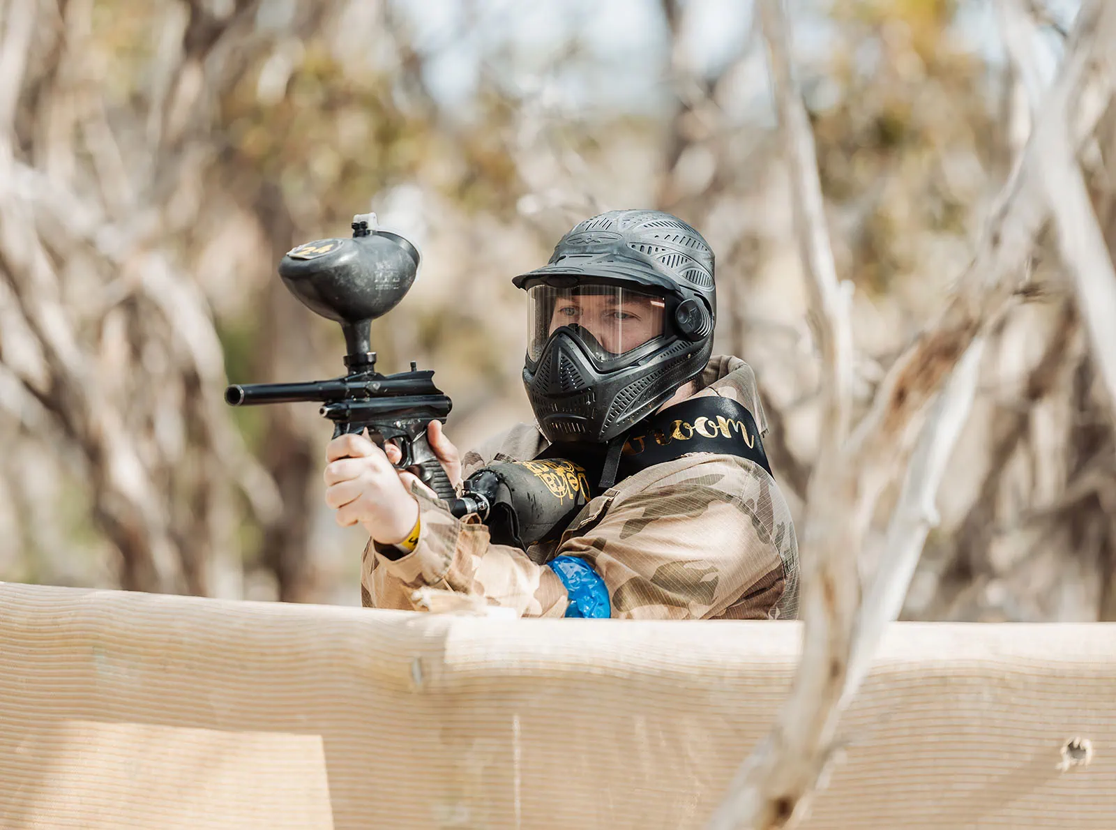 monarto delta force bucks vs hens paintball party 14 Person playing paintball in camouflage gear aiming marker in outdoor setting.